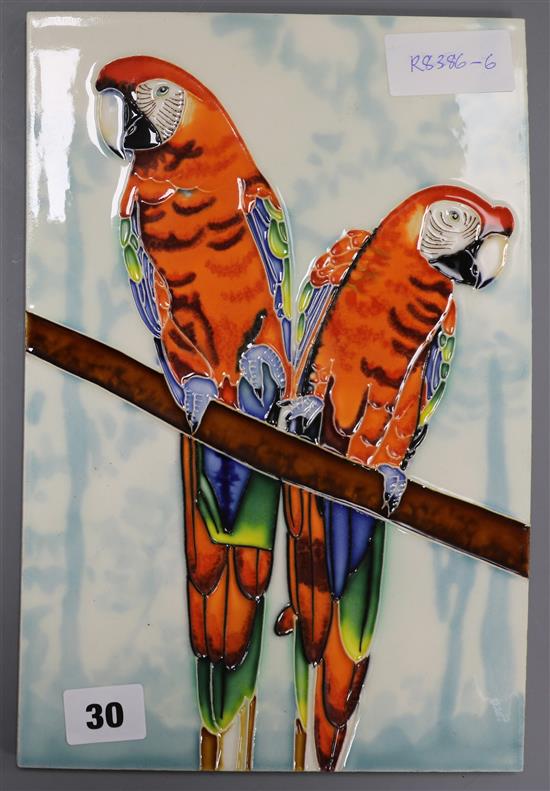 A ceramic plaque decorated with two parrots on a branch 30 x 20cm